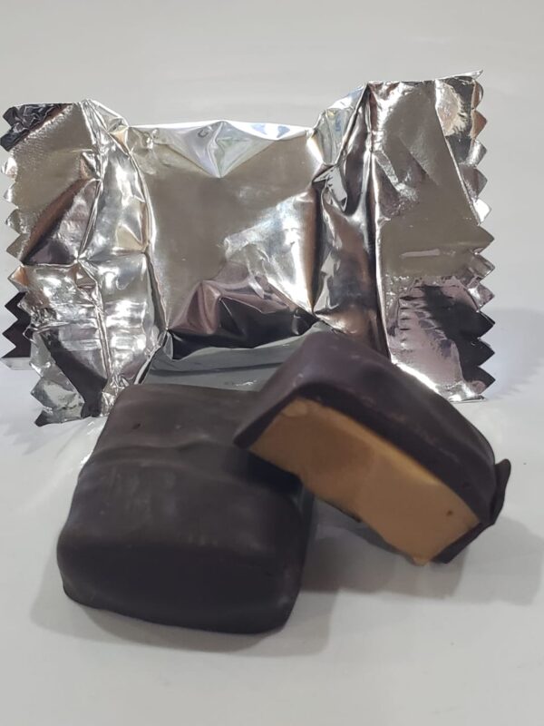 A chocolate covered peanut butter sandwich sitting on top of foil.